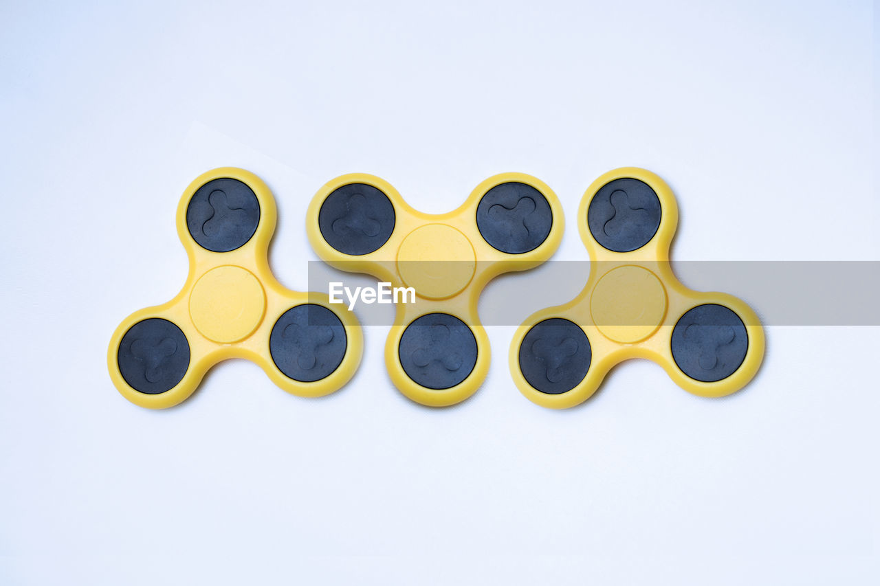 Yellow fidget spinners over white background