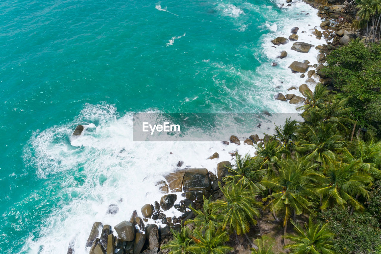 HIGH ANGLE VIEW OF WAVES SPLASHING ON ROCK