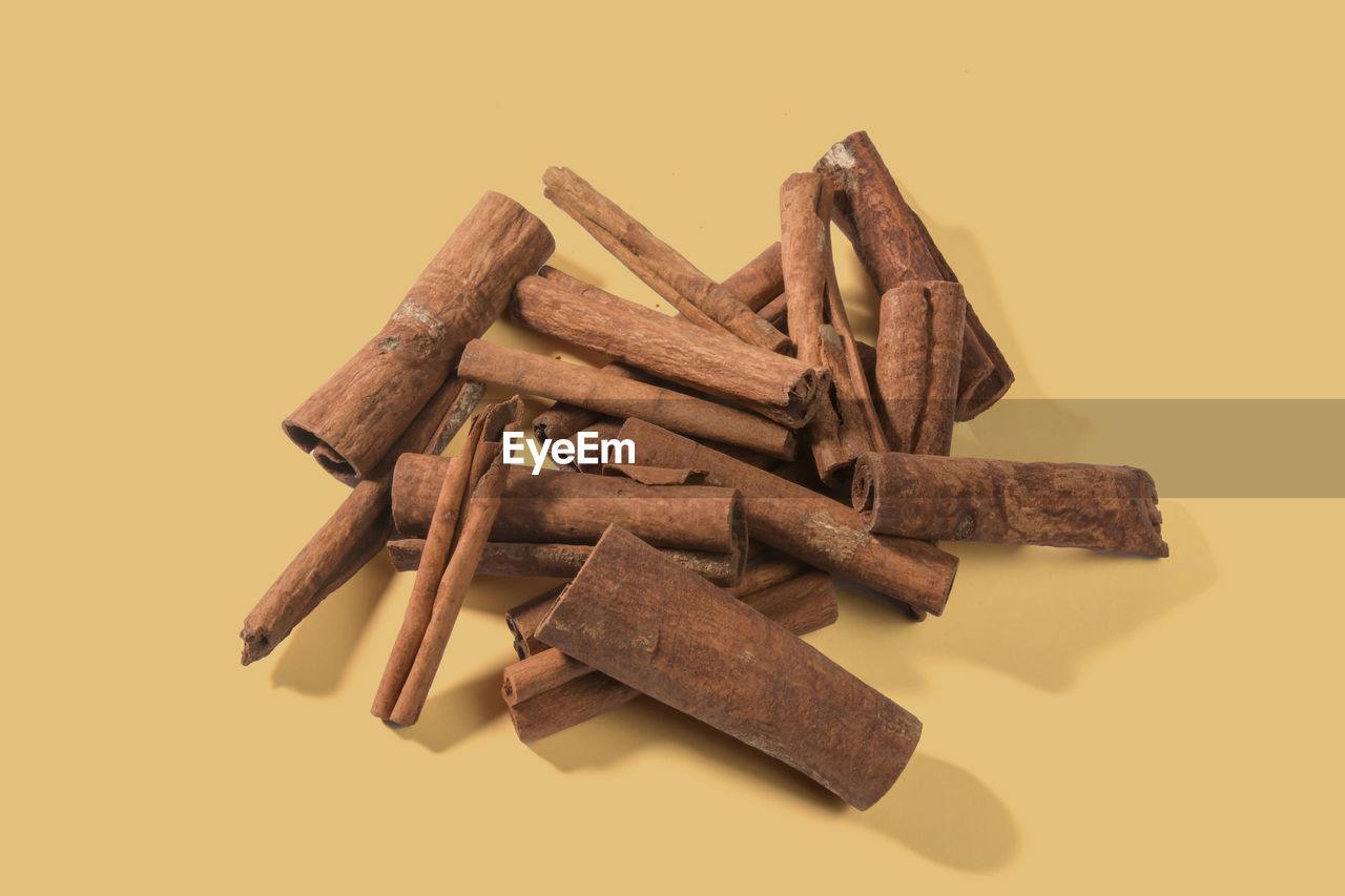 Aromatic dry cinnamon sticks on color background, top view