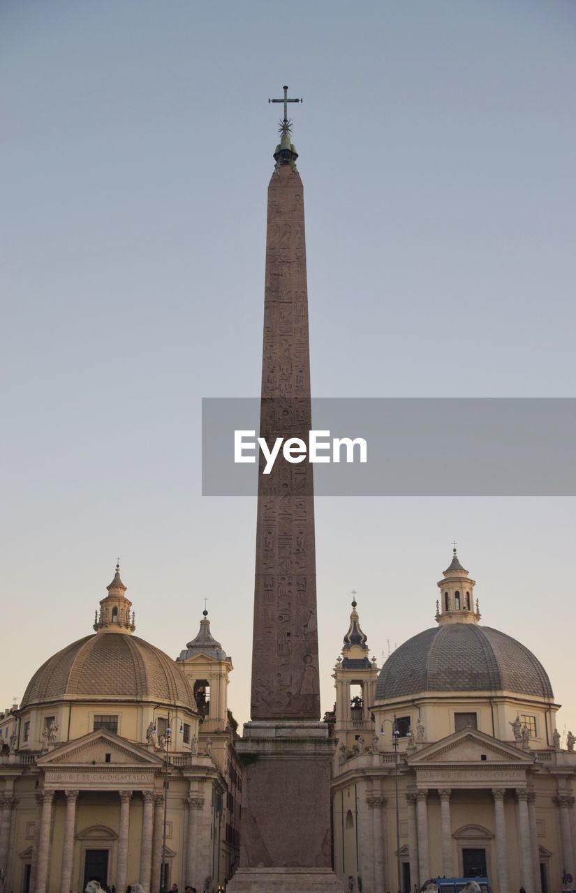 Low angle view against clear sky of twin churches and obelisk in piazza del popolo 