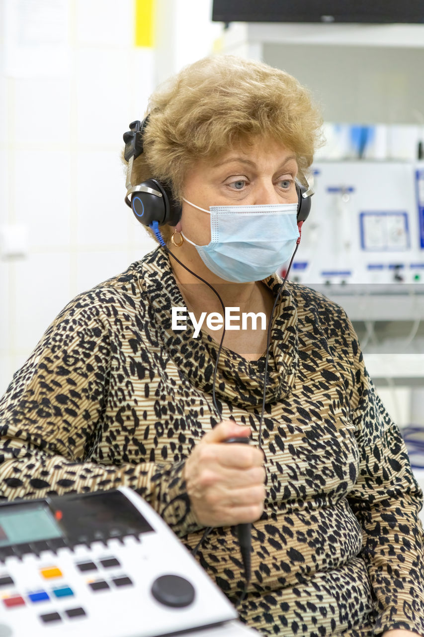 Audiologist checks the hearing of an older woman