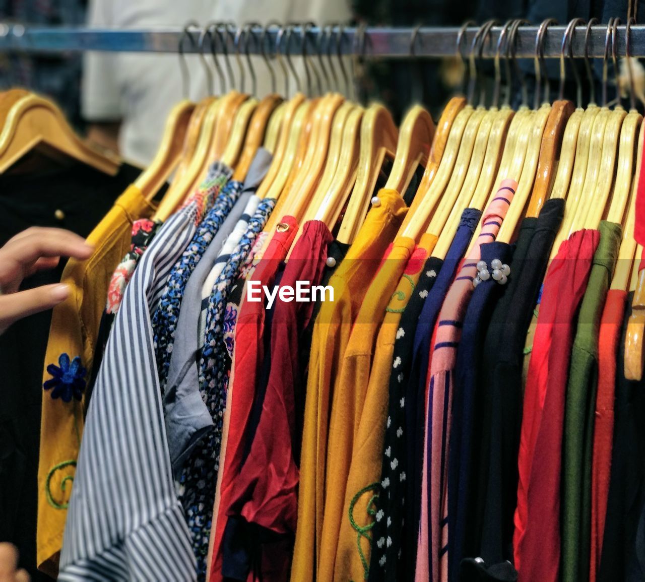 Various clothes hanging on rack in store