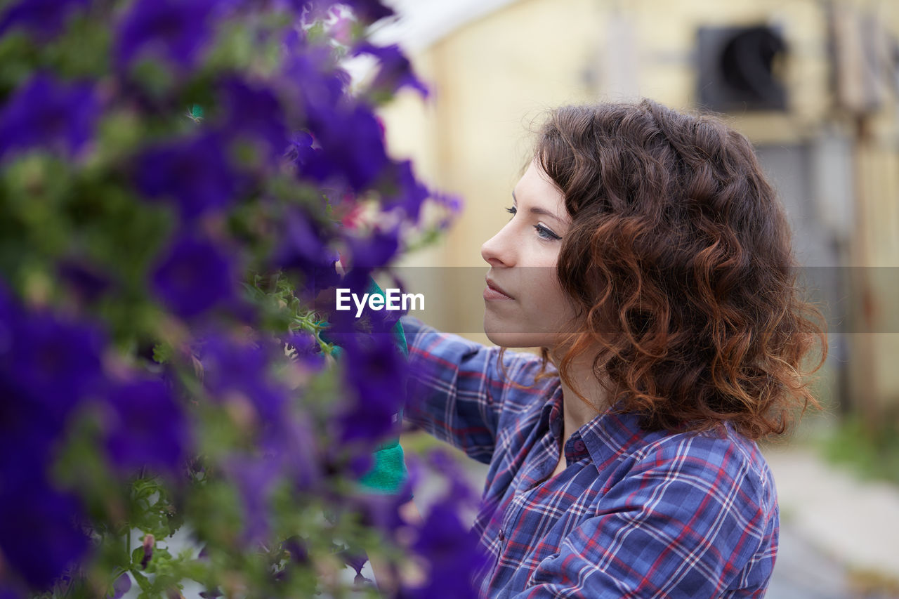 Close-up of woman by purple flowering plants