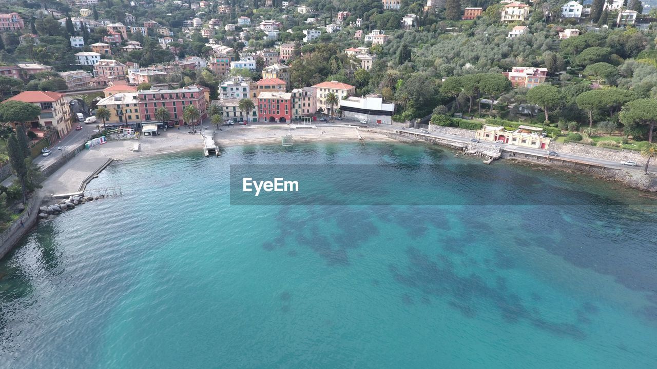 Scenic view of blue sea against buildings in city