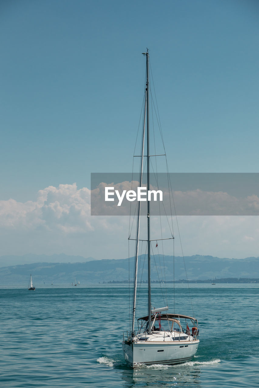 SAILBOAT SAILING IN SEA AGAINST SKY