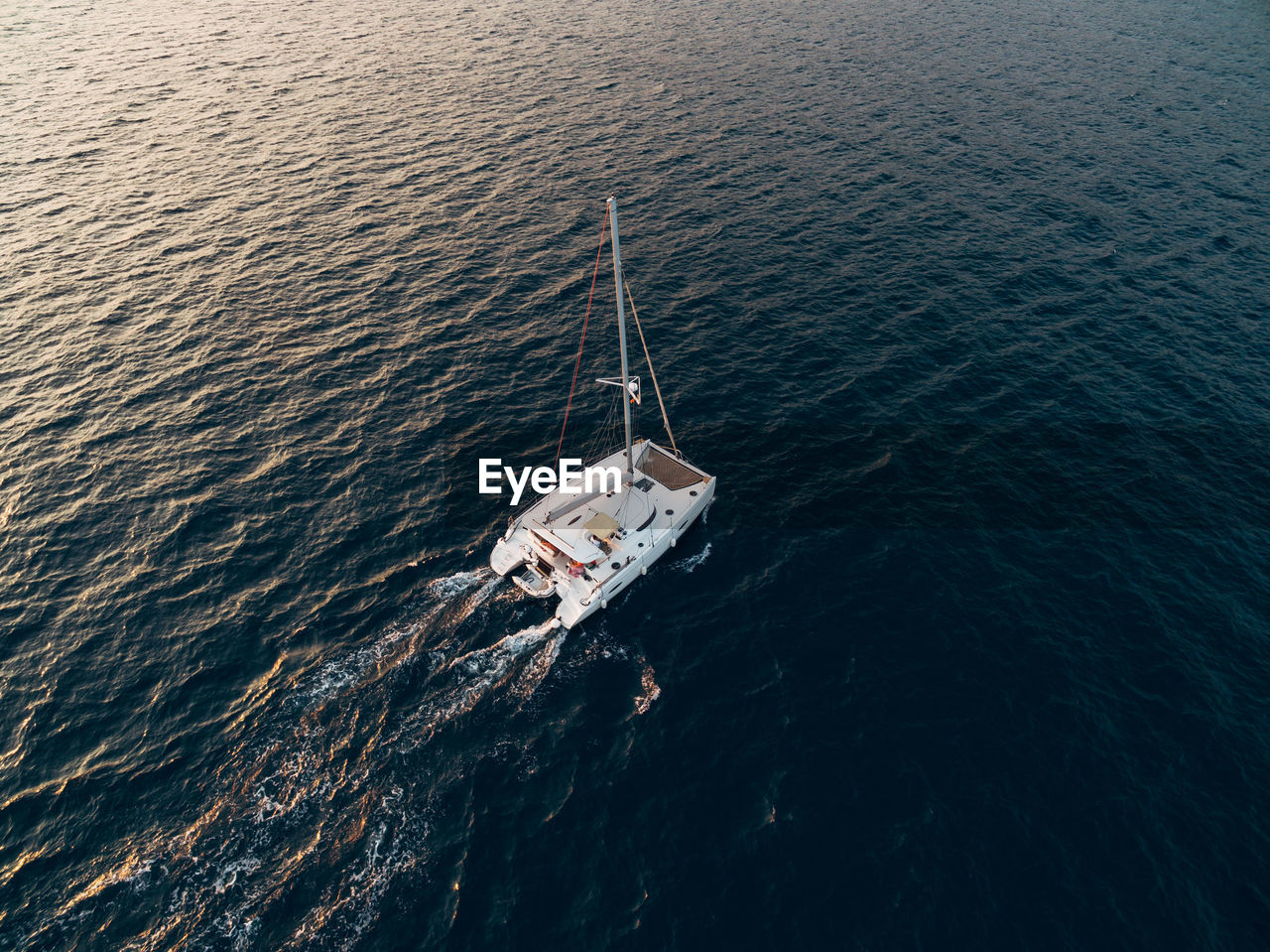 HIGH ANGLE VIEW OF SAILBOAT IN SEA