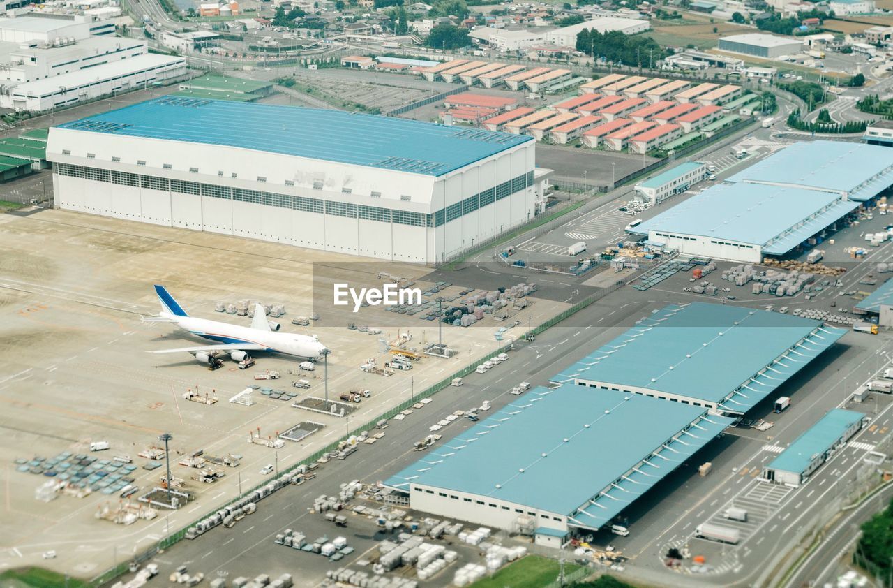 High angle view of airplane flying over cityscape