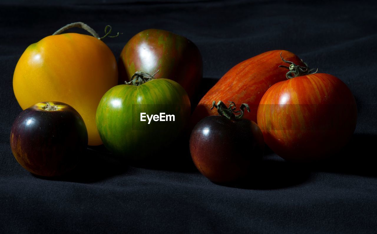 CLOSE-UP OF FRUITS ON TABLE AGAINST BLACK BACKGROUND