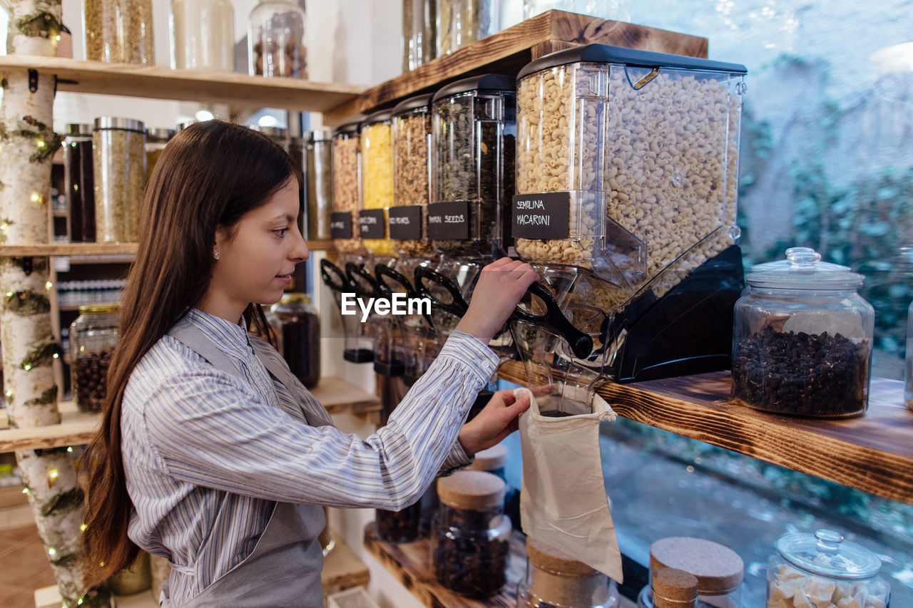 Side view of young woman working in store