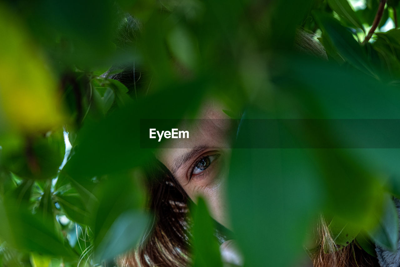 Close-up portrait of woman standing amidst plants