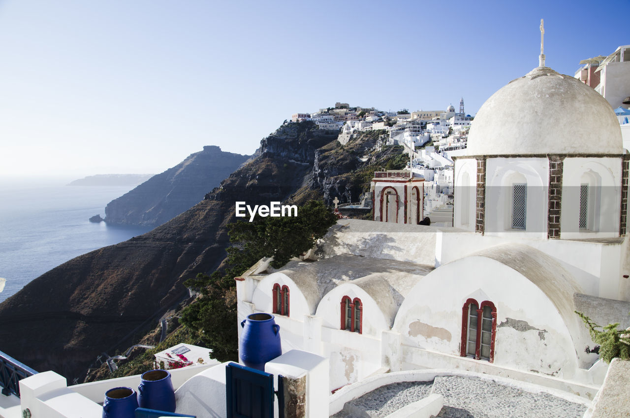 Old town by coastline against sky