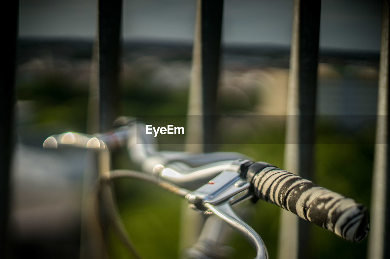 Close-up of bicycle handle by railings 