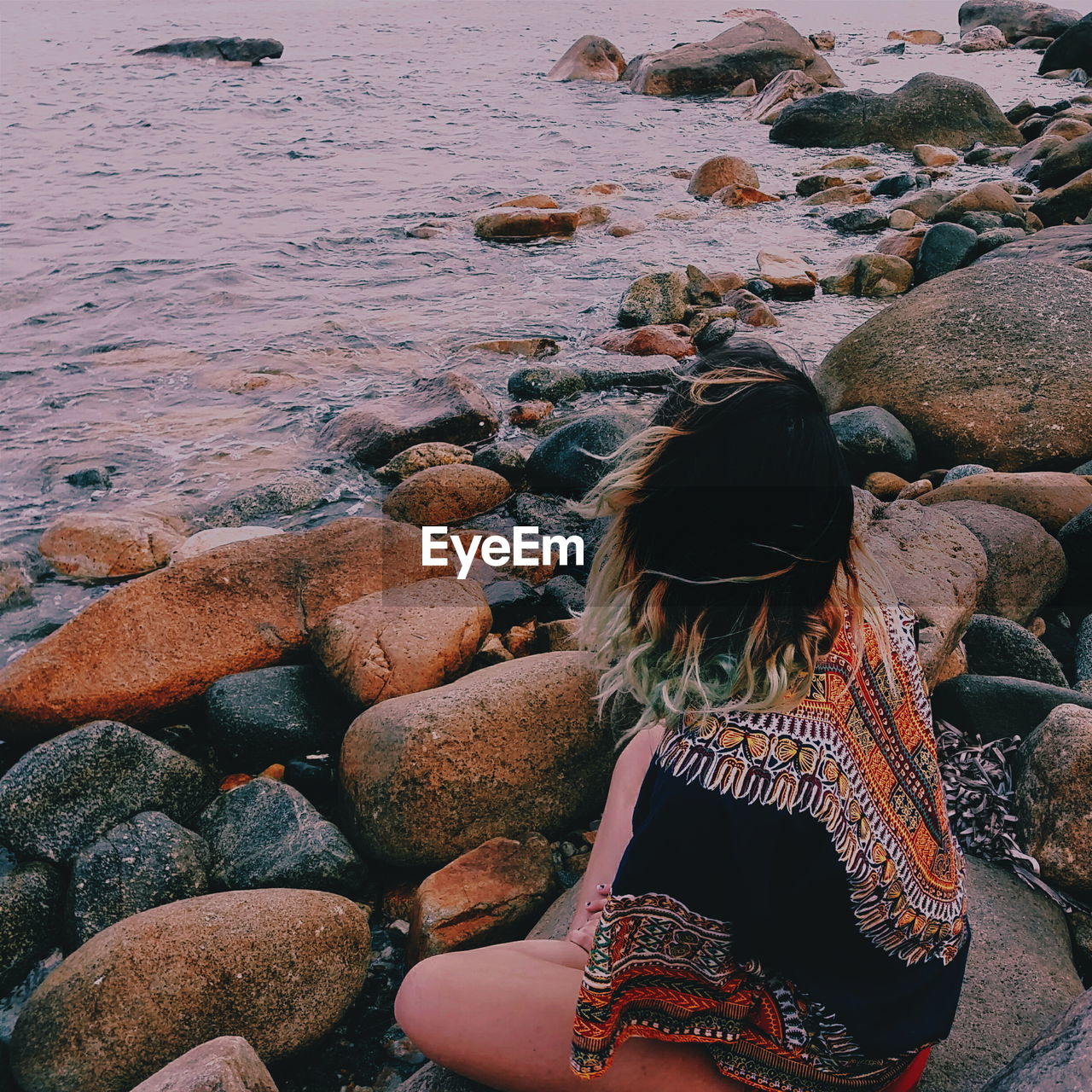 Rear view of woman sitting at beach