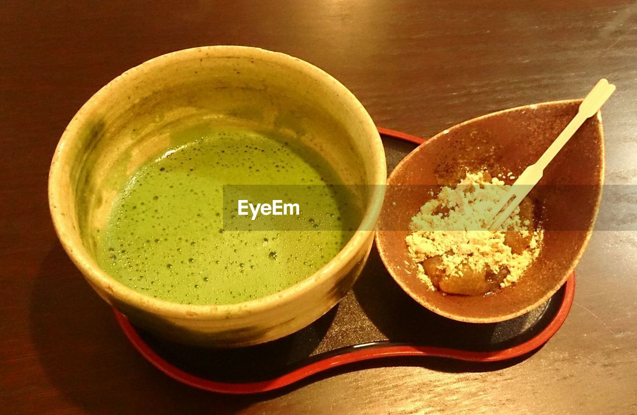 Close-up of matcha tea with food served on table