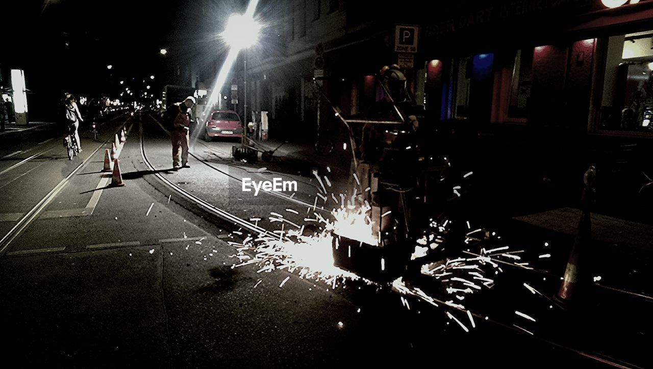 People working on tramway at night