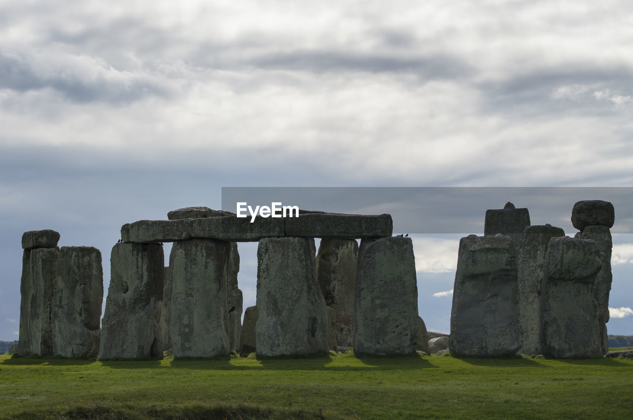 Built structure on field against cloudy sky