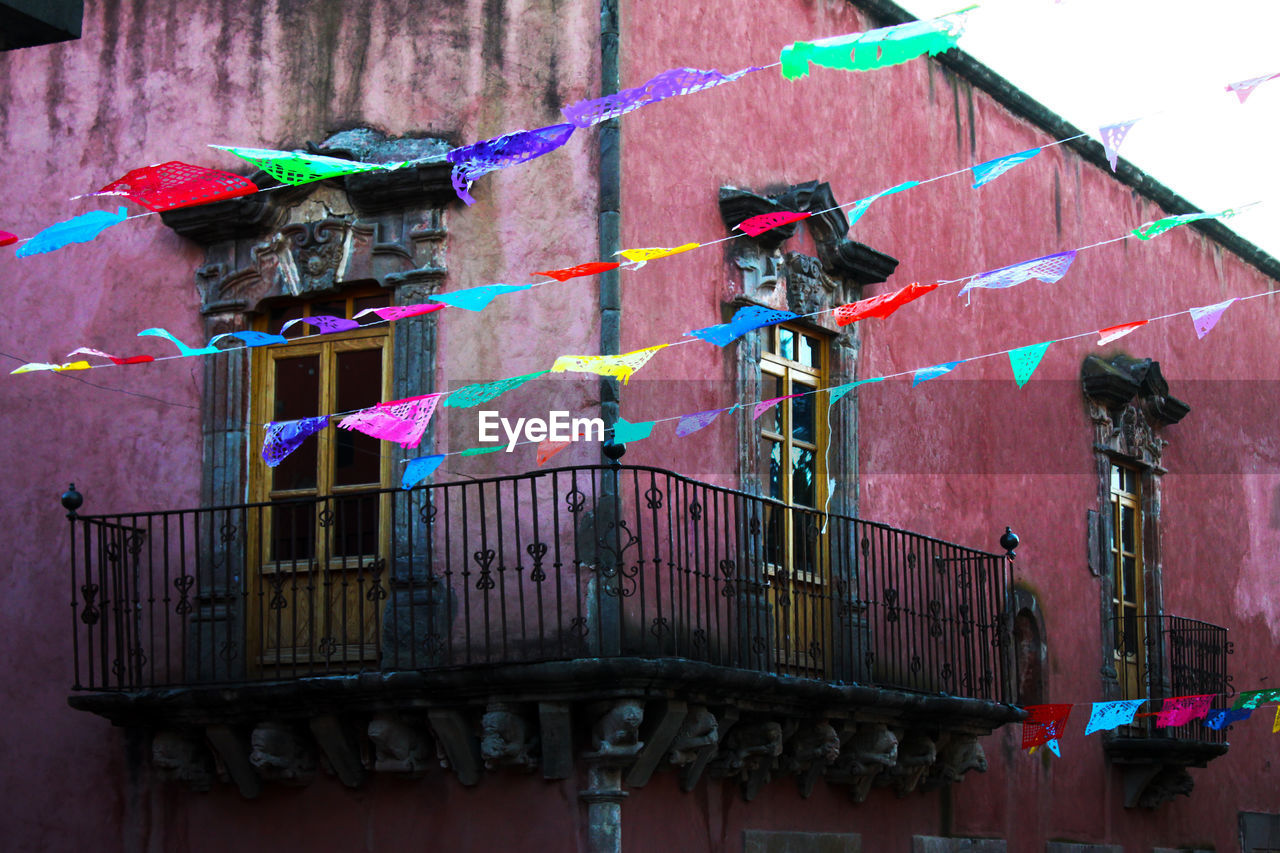 LOW ANGLE VIEW OF MULTI COLORED BUILDING AGAINST WALL