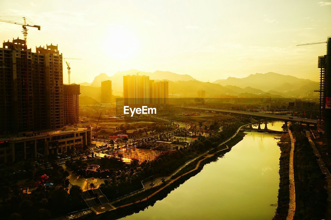 High angle view of river in city during sunset