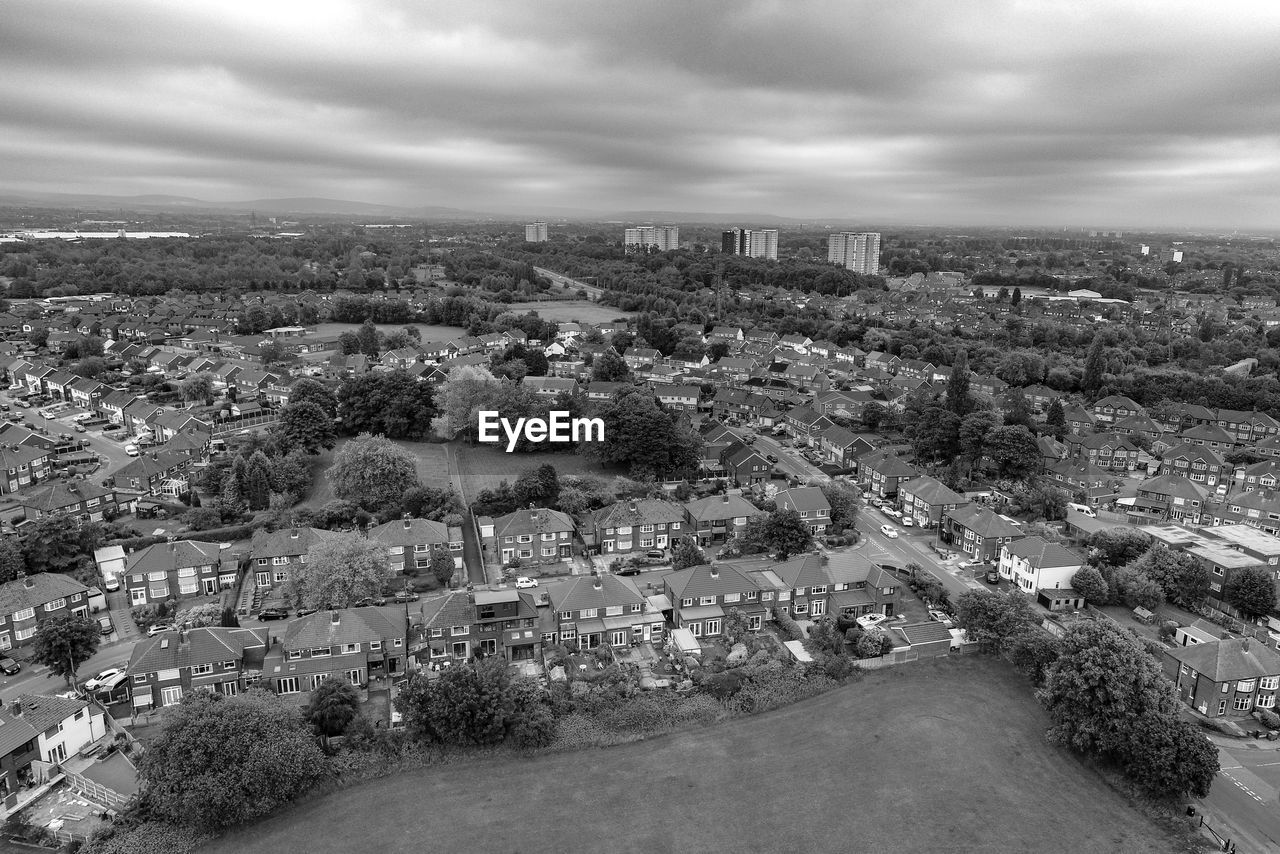 Aerial view of townscape against cloudy sky