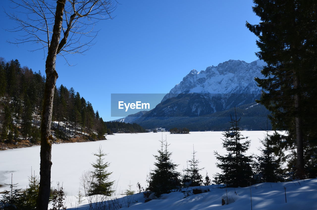 Scenic view of snowcapped mountains against clear blue sky