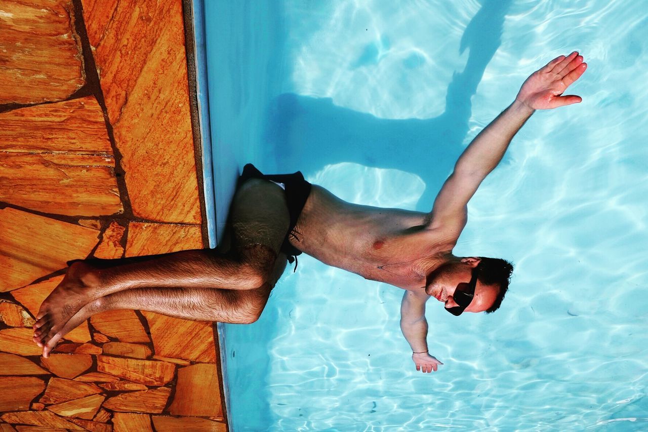 High angle view of man floating on water in swimming pool