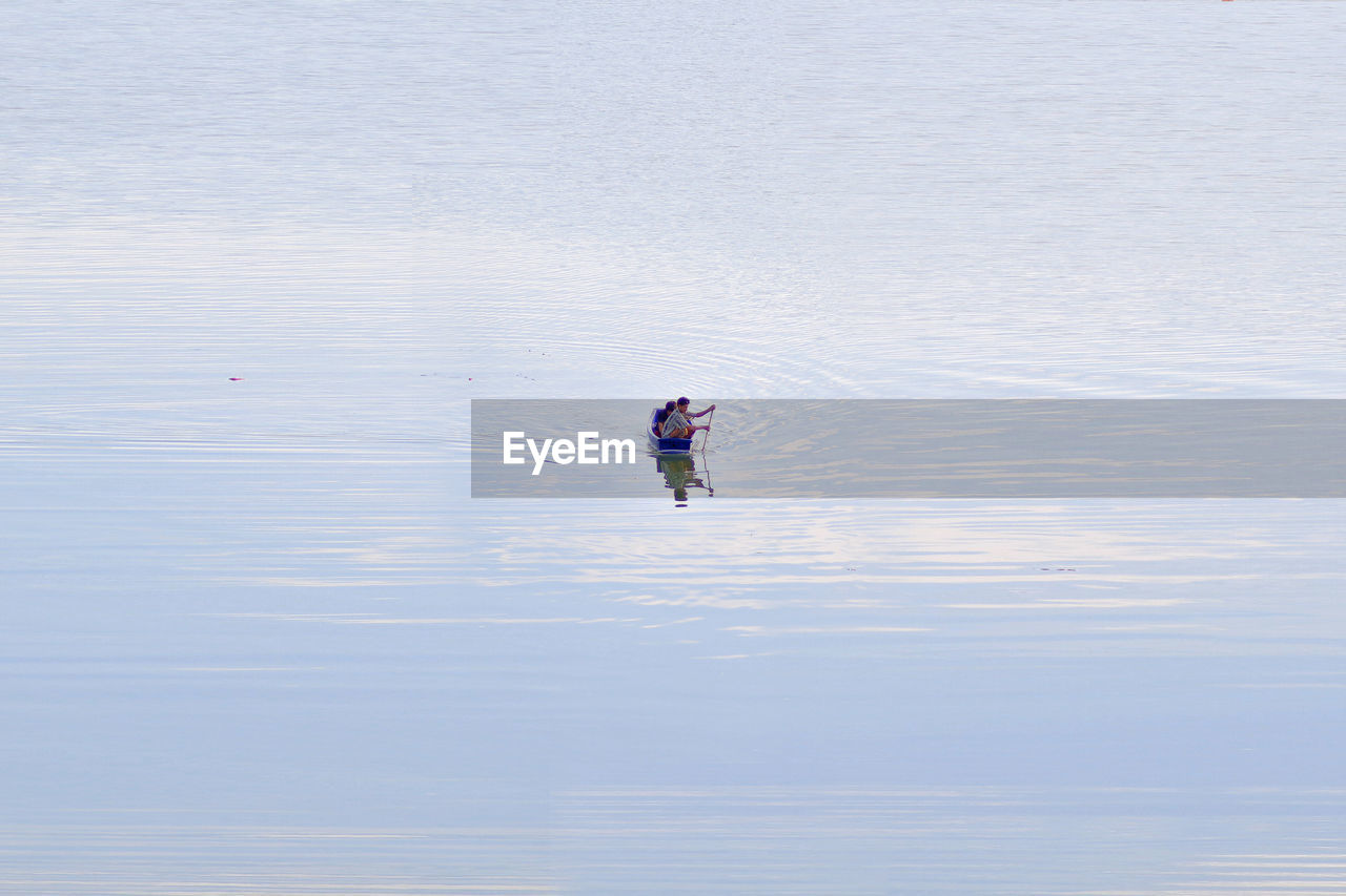 Mid distance view of people boating in lake
