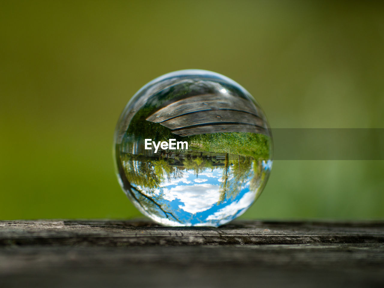 UPSIDE DOWN IMAGE OF CRYSTAL BALL ON WOODEN TABLE