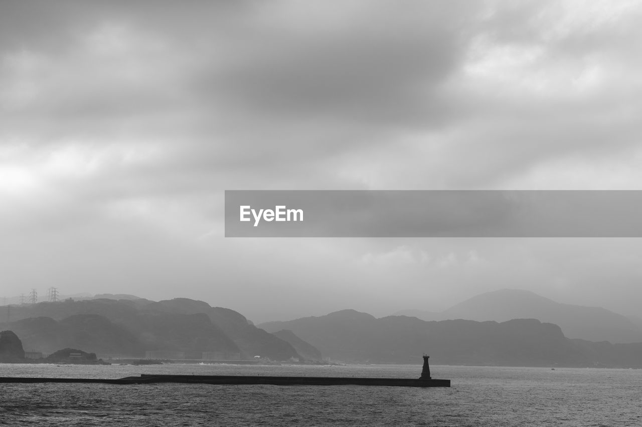 SCENIC VIEW OF SEA BY MOUNTAIN AGAINST SKY