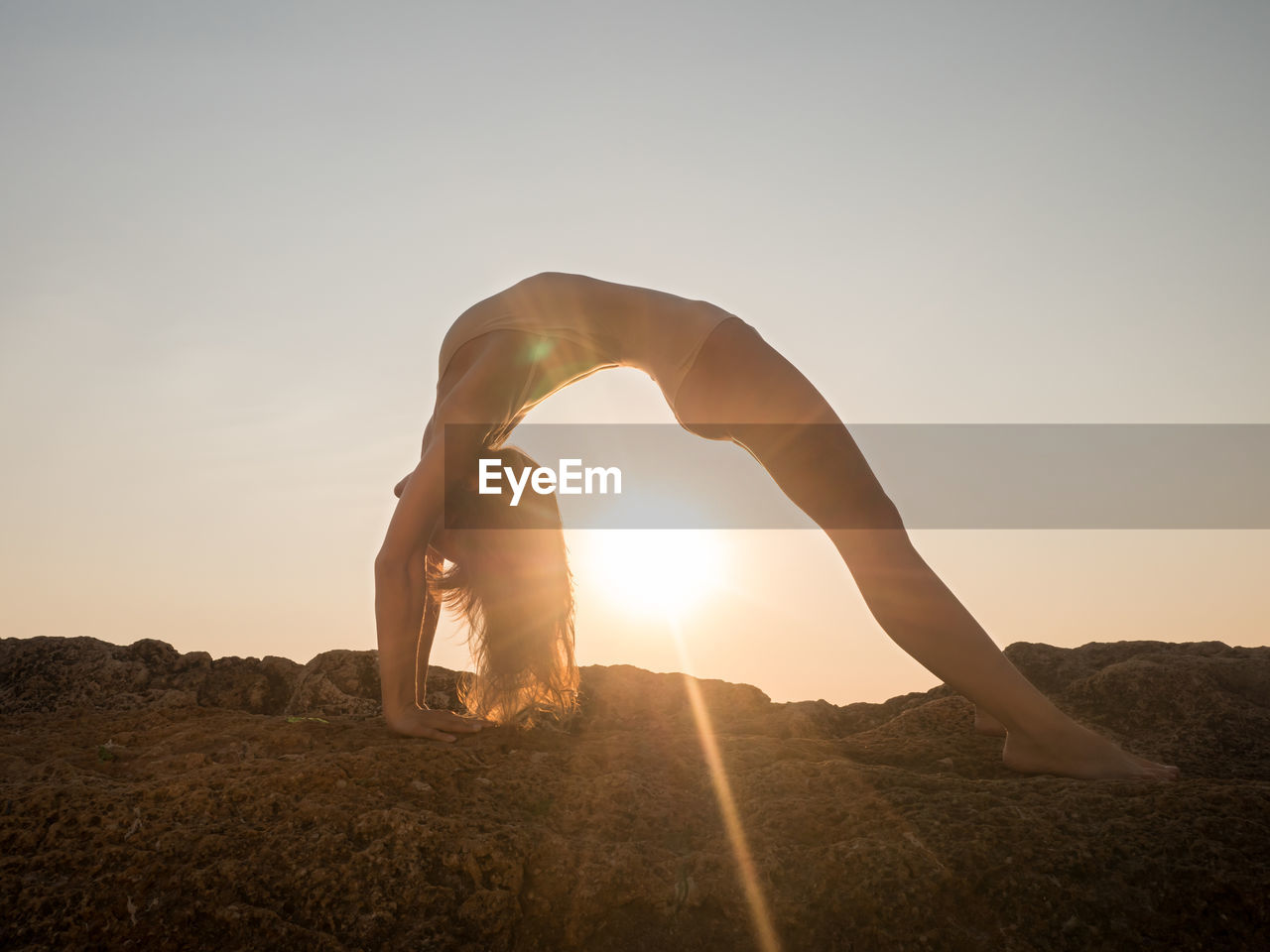 Woman doing yoga during sunset