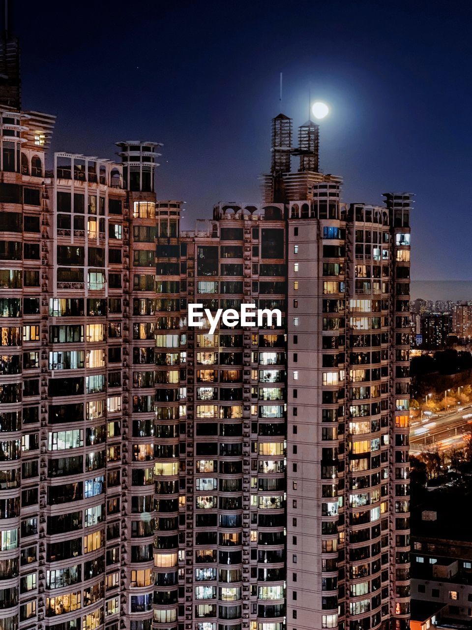 Modern buildings in city against sky at night