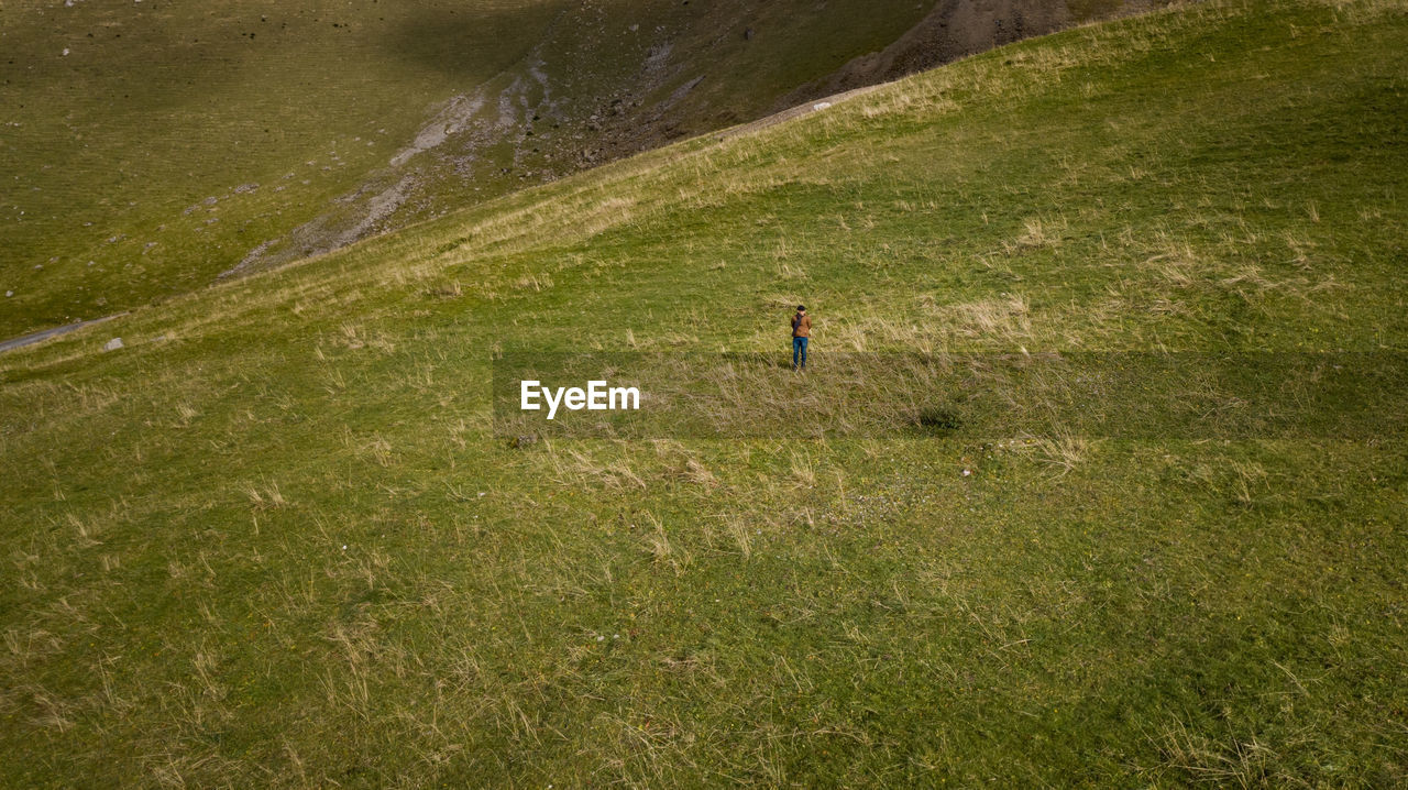 High angle view of man walking on grass field