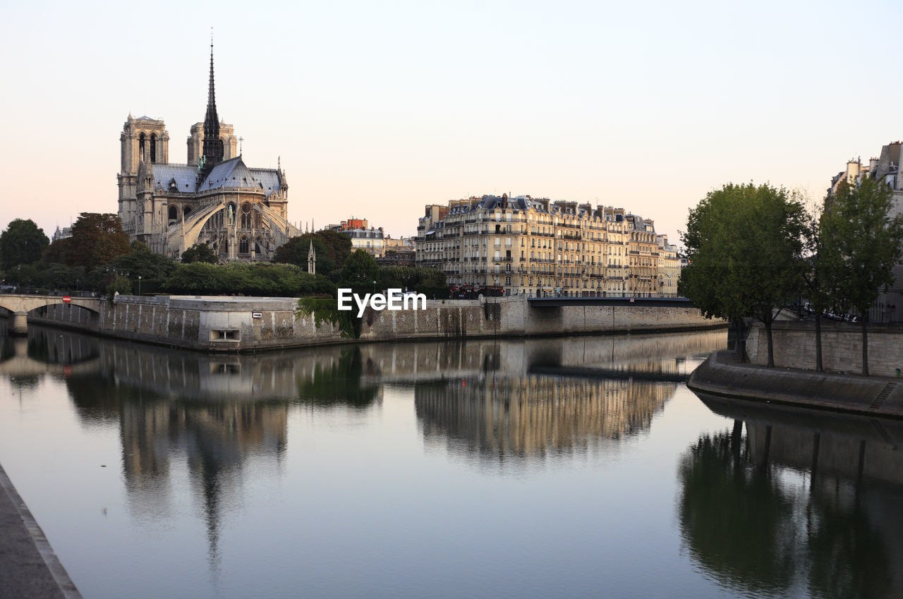 REFLECTION OF BUILDING IN RIVER AGAINST SKY