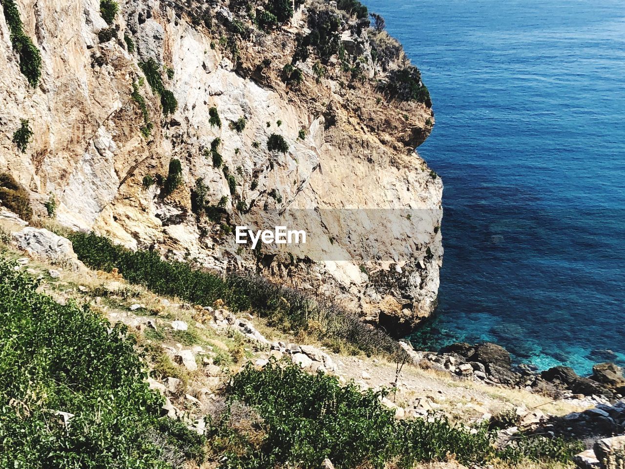 High angle view of rocks on sea shore