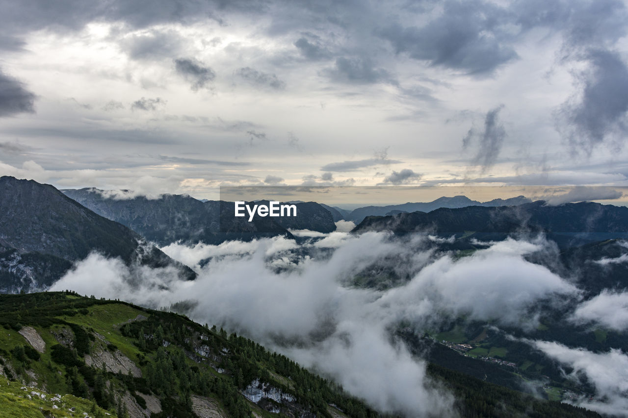 Scenic view of mountains against cloudy sky at dusk