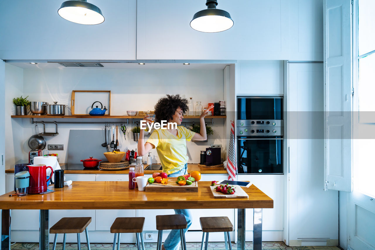 Woman dancing in kitchen at home