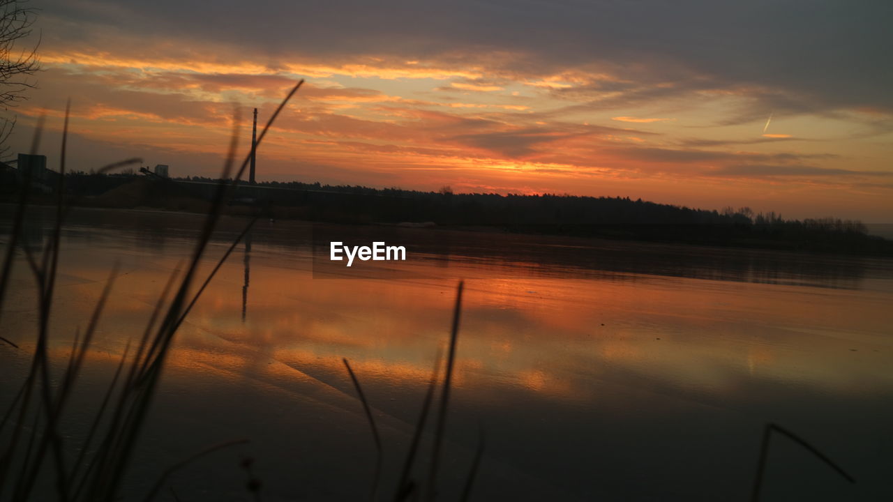 REFLECTION OF SKY ON LAKE DURING SUNSET