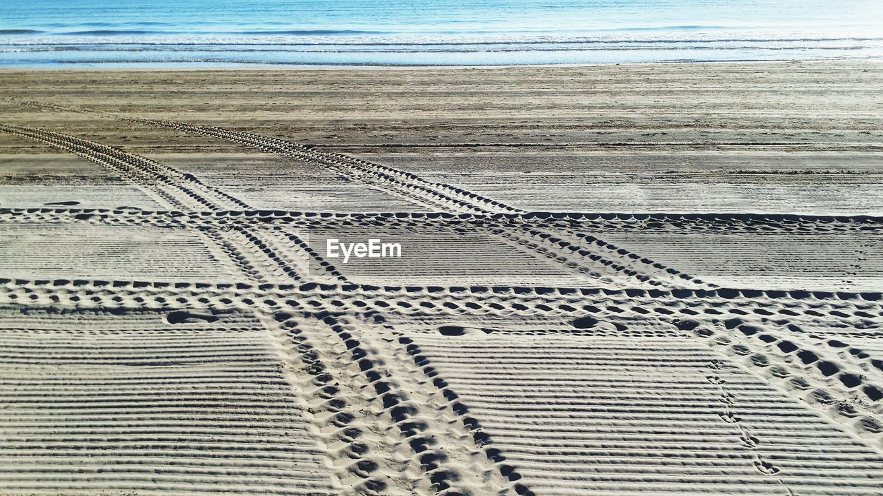 High angle view of tire tracks on beach