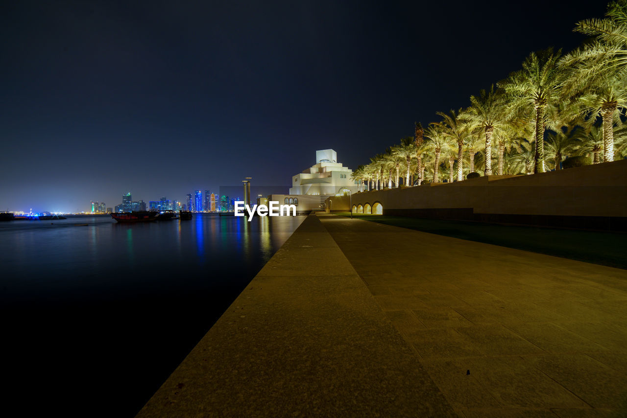 ILLUMINATED BUILDING AT WATERFRONT