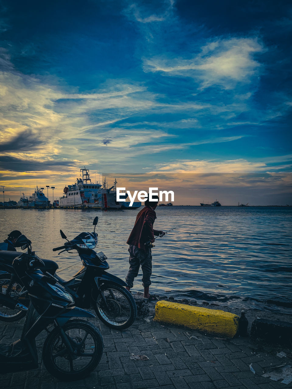 water, sky, transportation, bicycle, sea, cloud, mode of transportation, sunset, blue, nature, beach, evening, full length, horizon, vehicle, ocean, one person, land, dusk, travel, city, activity, beauty in nature, men, adult, nautical vessel, cycling, reflection, lifestyles, outdoors, architecture, scenics - nature, standing, coast, person, travel destinations, leisure activity, sunlight, land vehicle, bicycle wheel, sports, vacation, side view, horizon over water