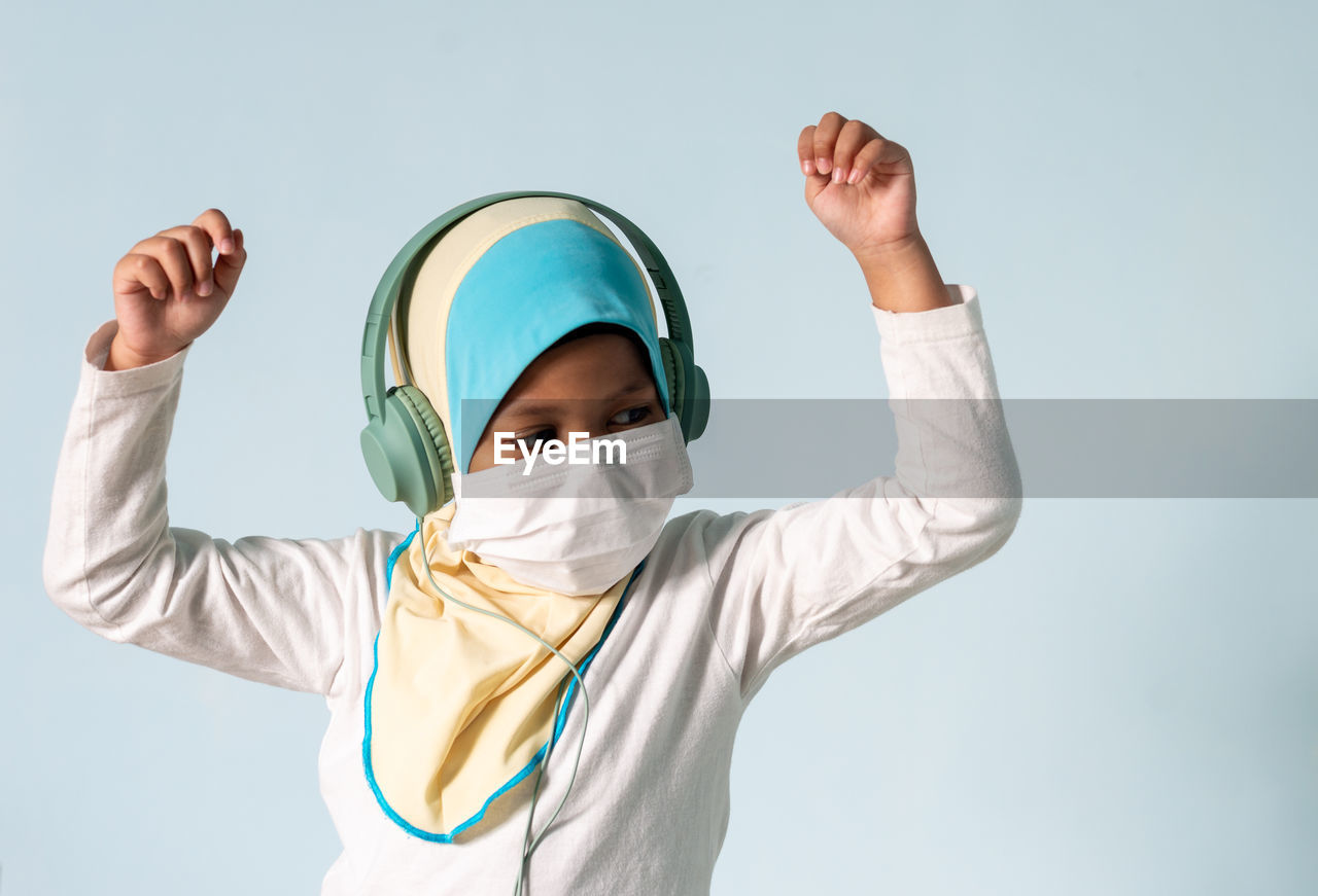 PORTRAIT OF CUTE BOY STANDING AGAINST GRAY BACKGROUND