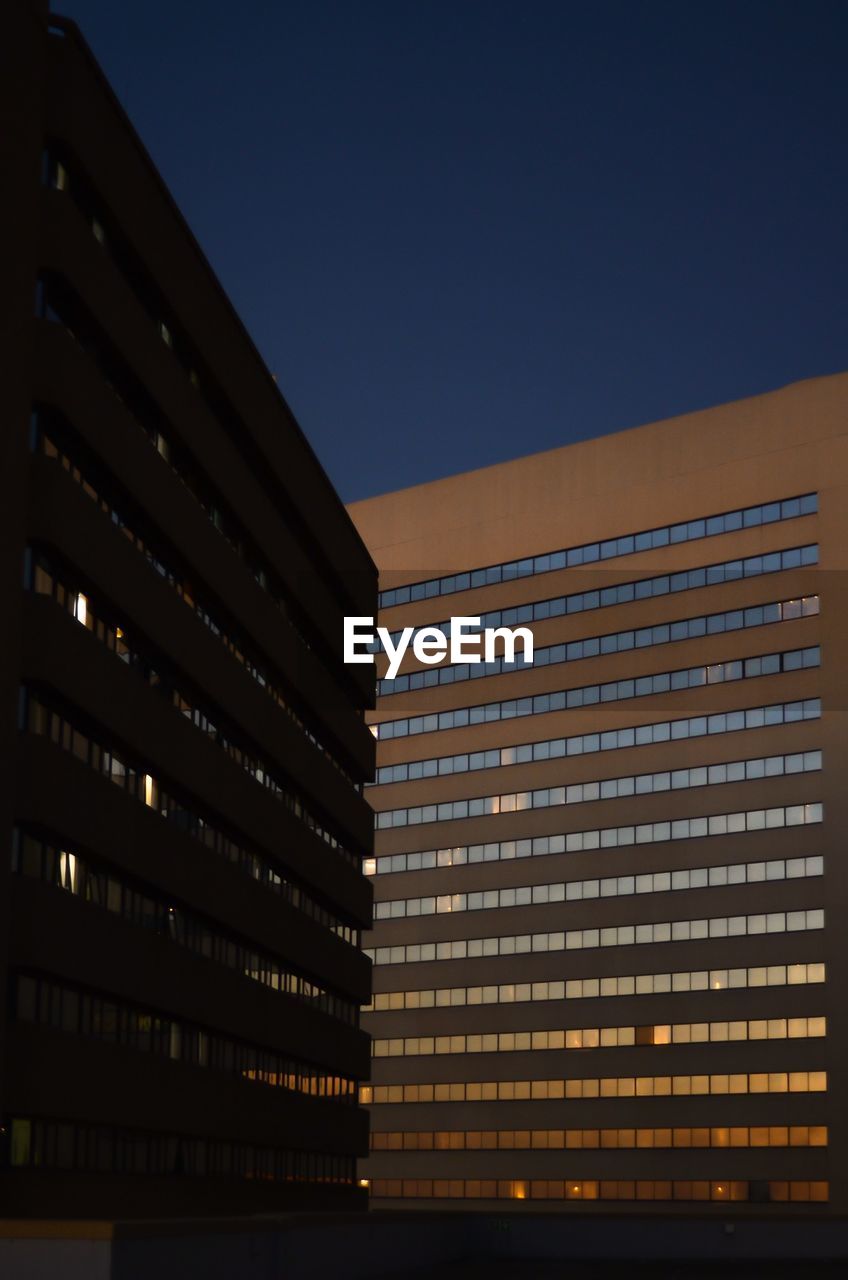 LOW ANGLE VIEW OF BUILDING AGAINST CLEAR SKY AT NIGHT