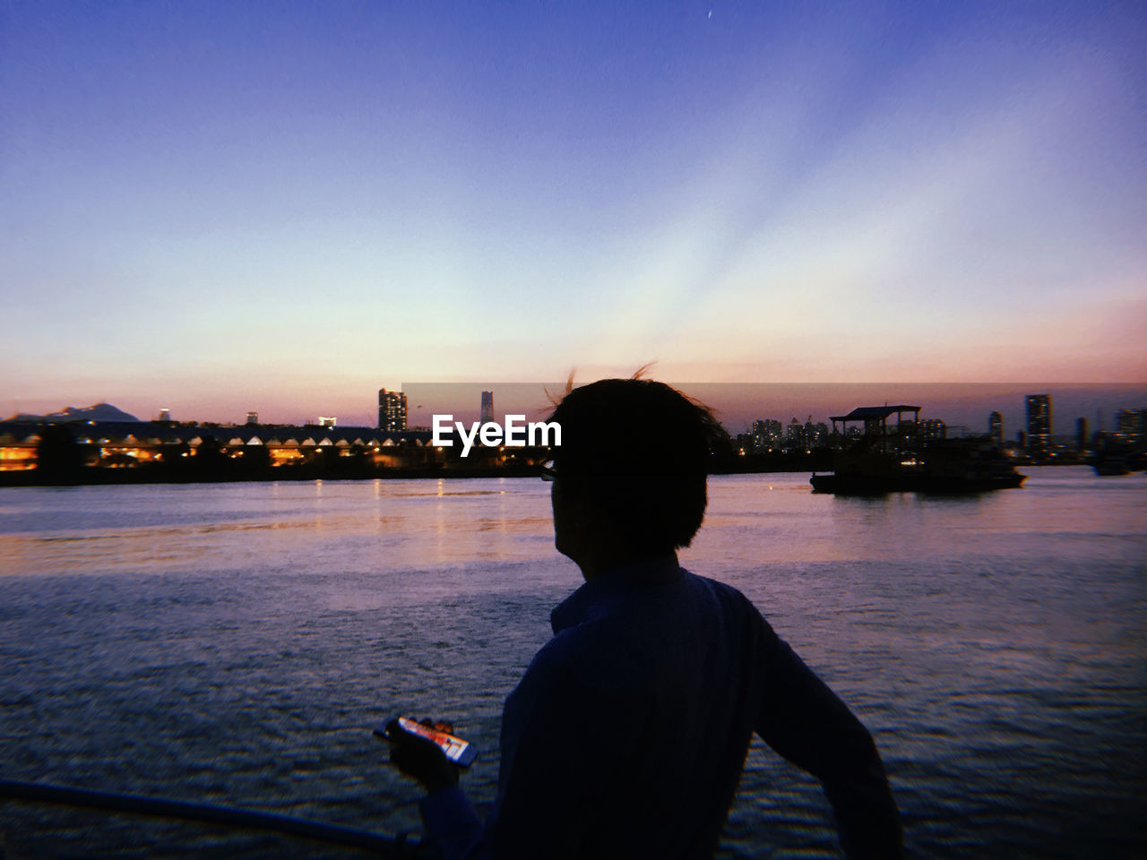 Rear view of silhouette man in river during sunset