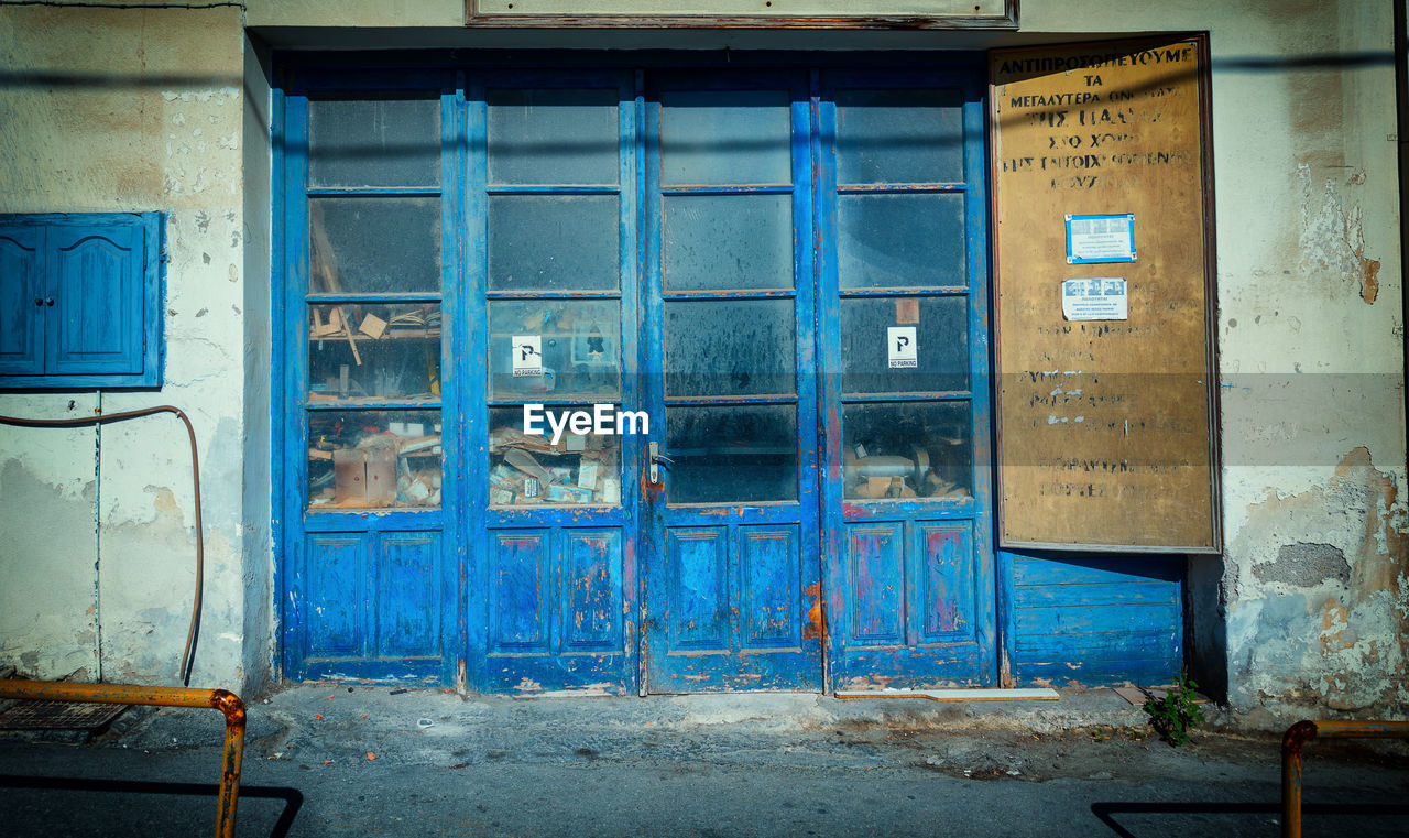 ABANDONED BUILDING WITH BLUE CLOSED DOOR