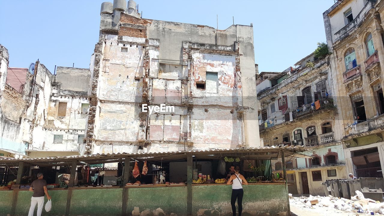 LOW ANGLE VIEW OF PEOPLE WALKING IN FRONT OF BUILDINGS