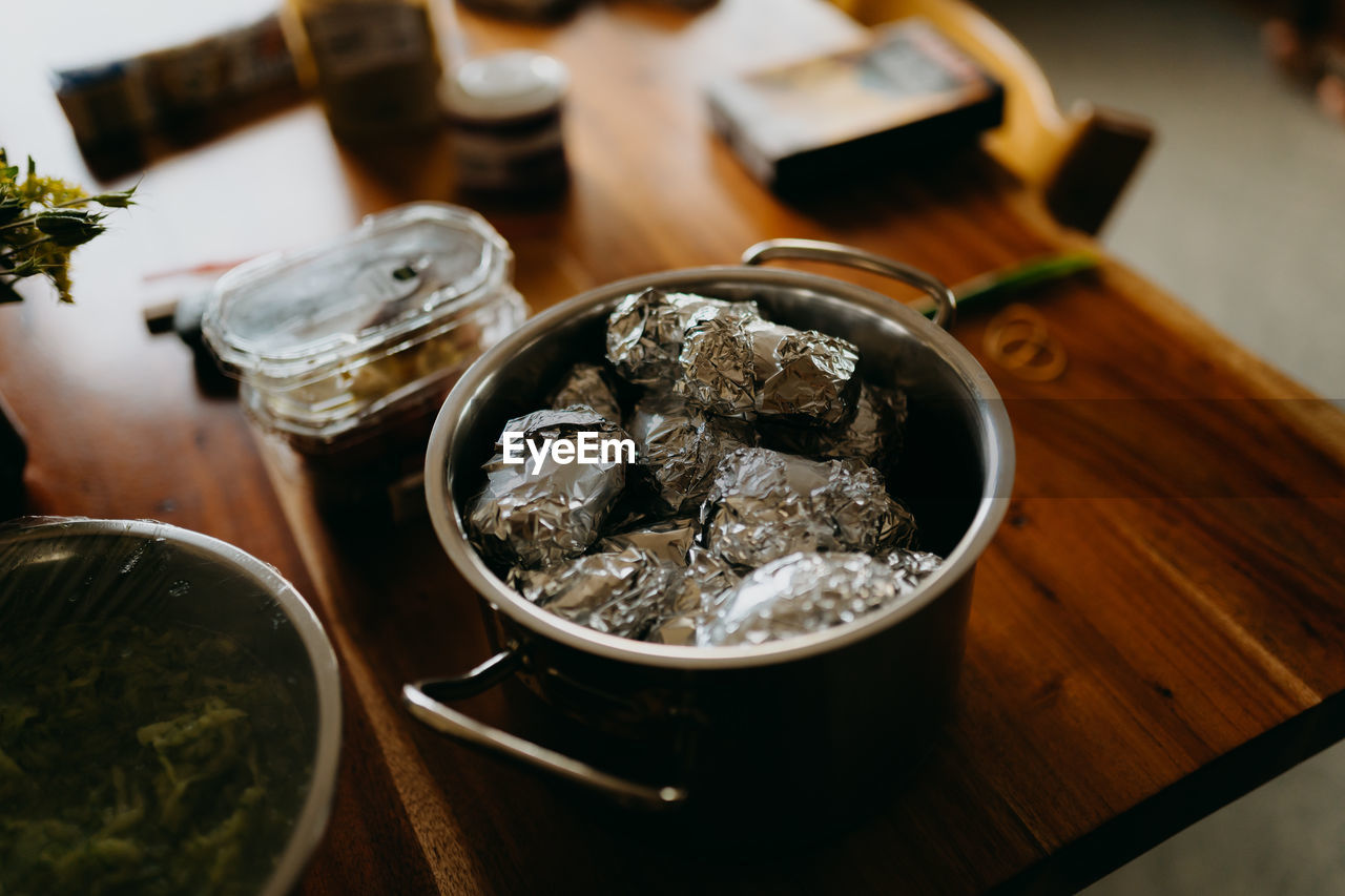 High angle view of baked potatoes in foil on table