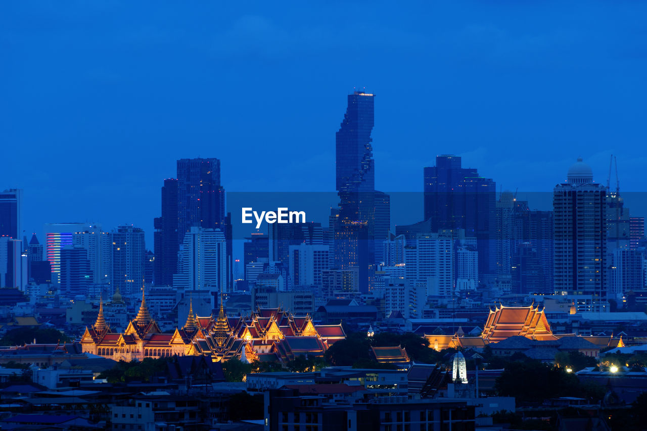 BUILDINGS IN CITY AGAINST SKY AT DUSK