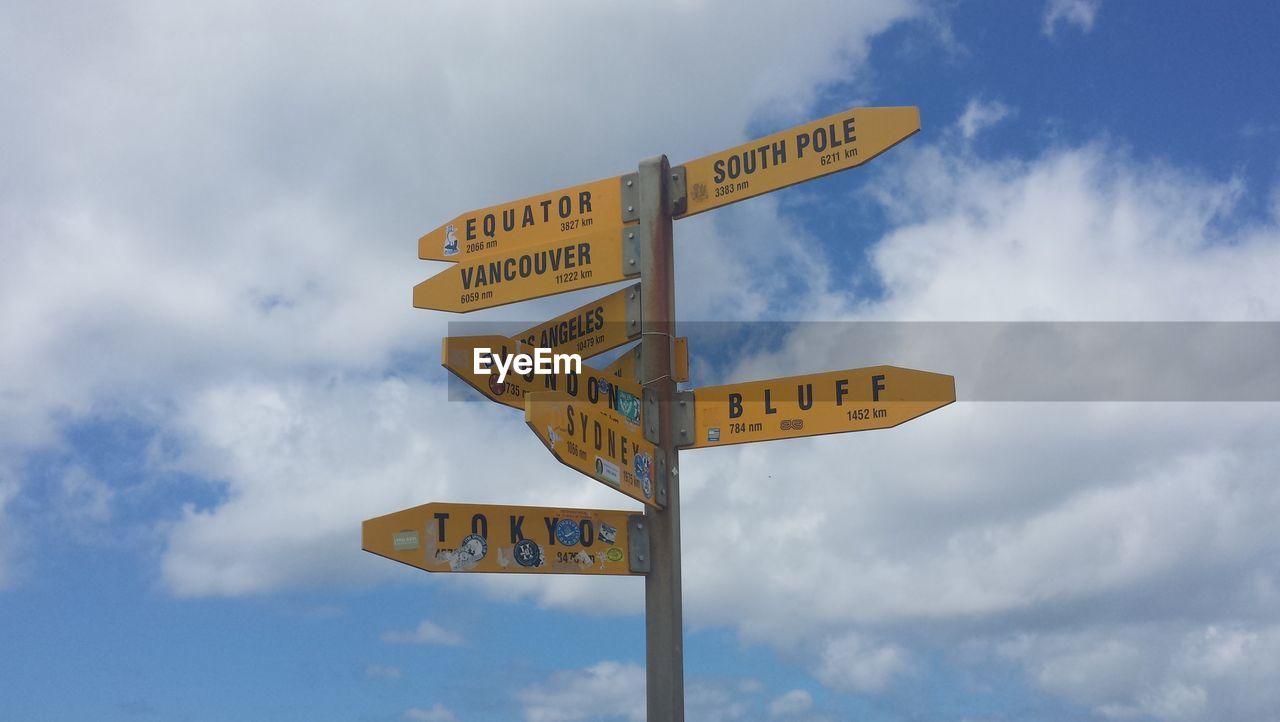 Low angle view of directional signs against sky