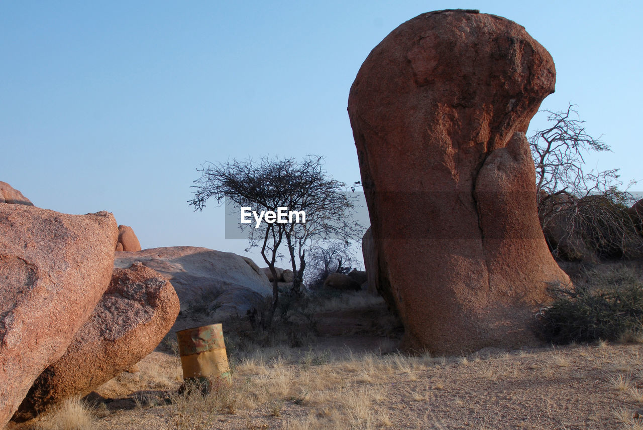 View of rock on landscape against clear sky