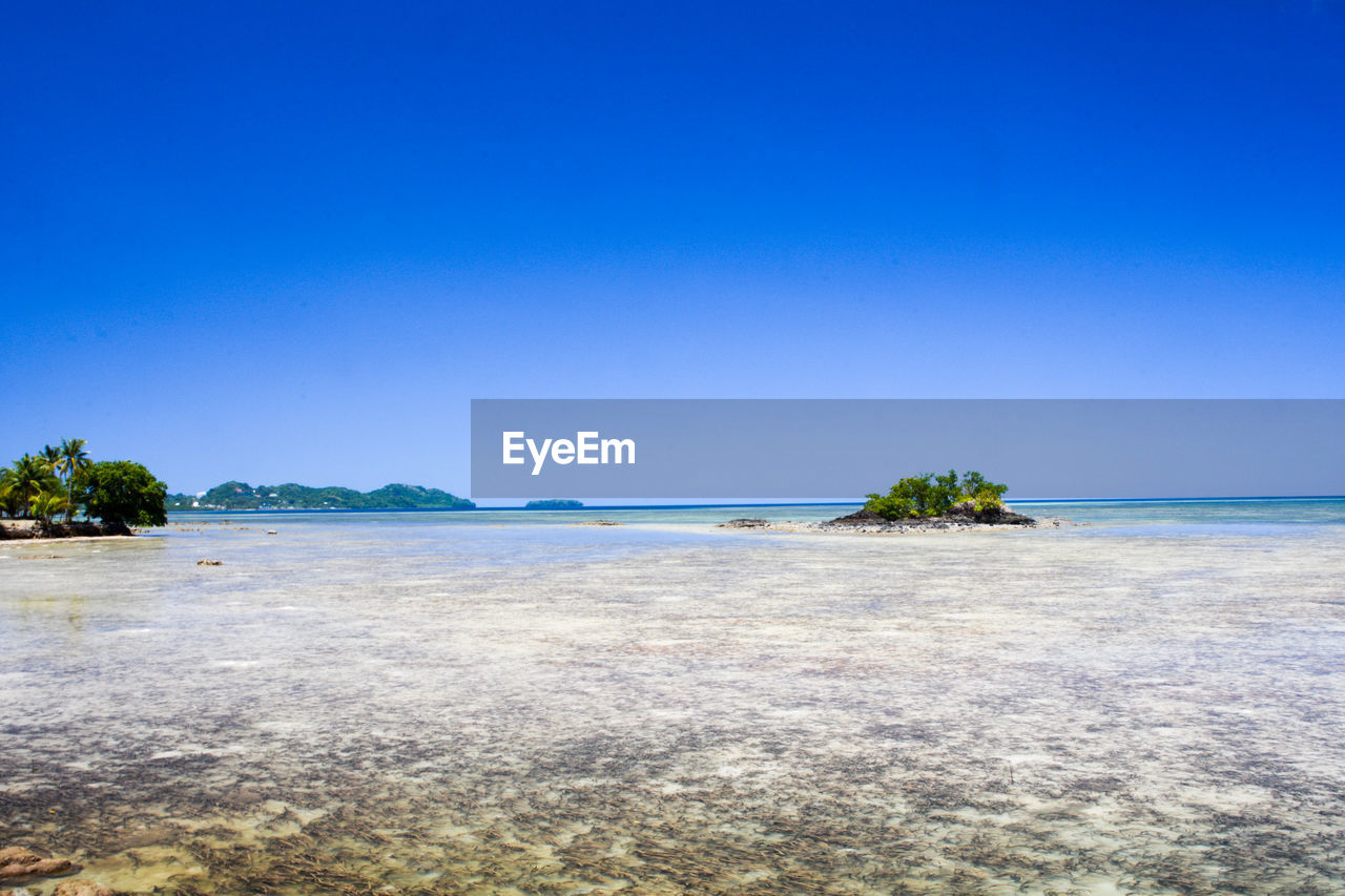 Scenic view of sea against clear blue sky