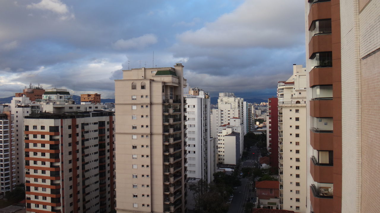 Buildings in city against cloudy sky